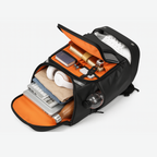 Black Dependz 7716 backpack with orange interior compartments containing various items on a white background